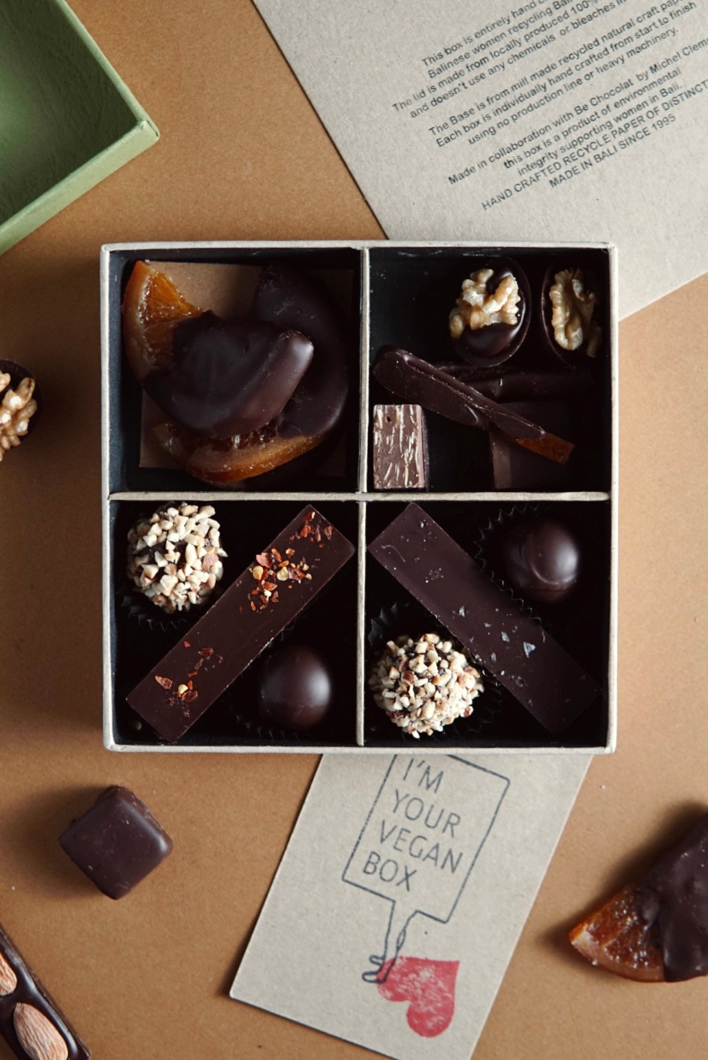 Vegan box of handmade chocolates flat lay with chocolates coming out of the box